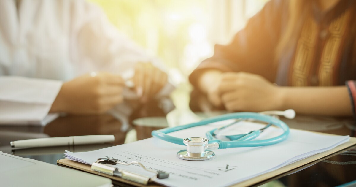 Stethoscope with clipboard and Laptop on desk,Doctor working in hospital writing a prescription, Healthcare and medical concept,test results in background,vintage color,selective focus
