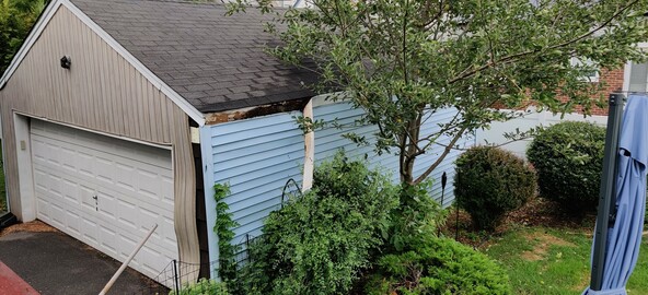 A piece of siding hanging off a garage