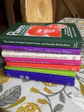 A stack of hardback books, mostly collections of letters by the novelist John Cowper Powys.