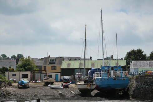 Hankock's Yard, an old no longer active dockyard, now acting as a local musem documenting the shipbuilding history and heritage of PDock. Seen from the water side at low tide with small sail boats sitting on the silt