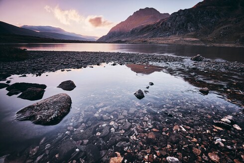 An early sunrise at Cwm Idwal in Eryri, Snowdonia. The sun, about to break over the mountain Tryfan. The lake, still and calm.