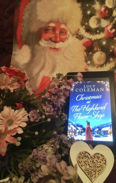 Book cover of Lucy Coleman’s book Christmas At The Highland Flower Shop. A heart and flowers central to the storyline