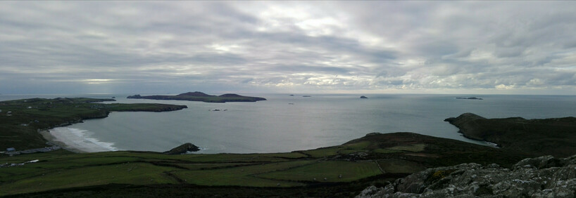 Photo of Whitesands Beach viewed from Carn Llidi, with the view stretching out to sea under a moody grey sky.