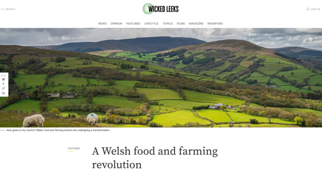 A landscape view of rural Wales with sheep in the foreground and mixed fields, upland and woodlands behind. Title of the blog post 'A Welsh food and farming revolution' is underneath