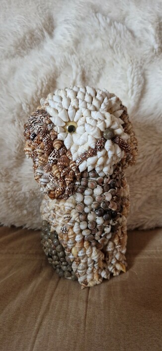 An ornament of a dog/puppy (a bit like a King Charles spaniel), about 20cm tall, covered in small shells to form the details.