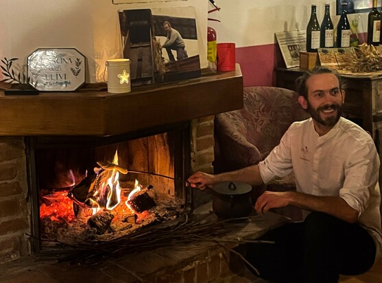 The cook from Aberteifi, making bread on a stick in the fireplace at the Cascina degli Ulivi in Italy.