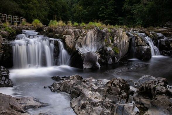 Cenarth Falls. A river causeway that features natural small waterfalls as the river meanders its way through the scene.