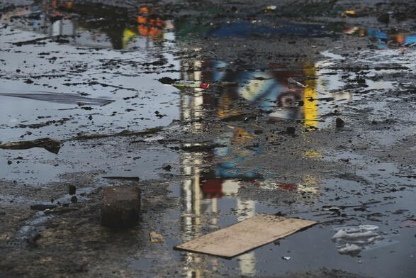 A reflection in a dirty grimy puddle of a fairground ride.