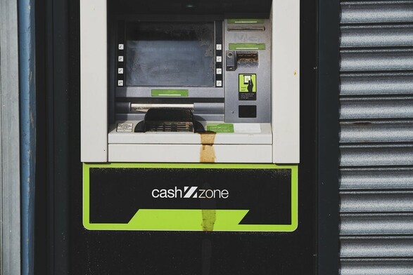 A cash machine that's out of order with a big dirty spilt liquid running down it.