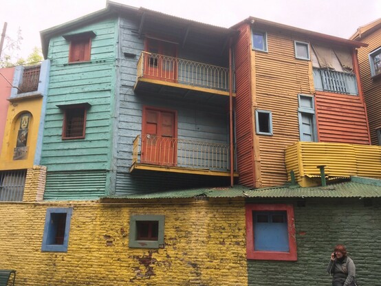 Image shows several plain windows in multi/coloured 4 storey apartment buildings in Buenos Aires
