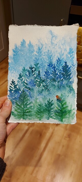 Watercolour painting of several layers of pine trees in blues and greens and a tiny Robin, perched on a branch in the foreground.