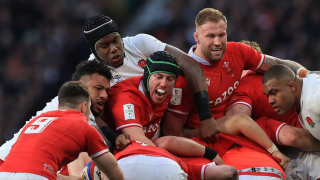 Welsh and English rugby players compete for the ball in a gaggle of red and white bodies