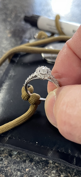 Diamond ring being held with two fingers 