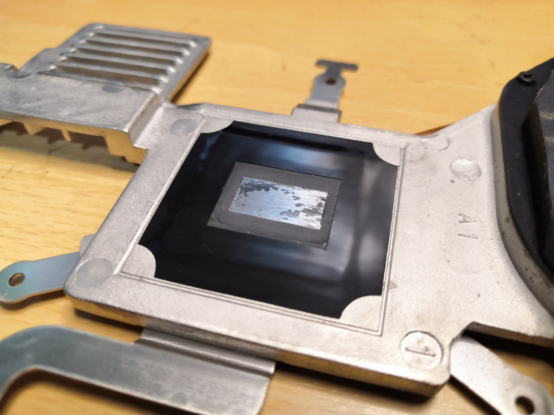 Underside of a laptop heatsink (the part in contact with the CPU die), showing some old leftover thermal paste (black marks on the silver). 