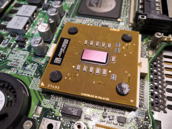 After: AMD Athlon laptop CPU with die visible (pink) after cleaning off the old thermal paste.