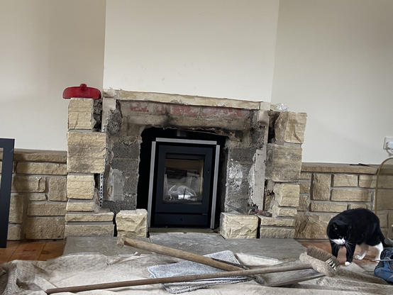 New multi burner stove set into former fireplace.  The surround of limestone is not yet rebuilt , so you can see the breeze blocks and bricks of the opening of the fireplace.  