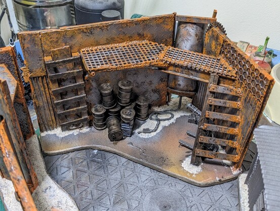 A piece of wargaming terrain being painted. Orange rust features prominently.