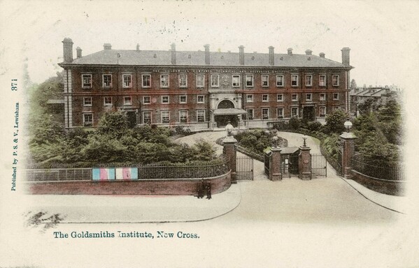 Old postcard showing the Goldsmiths' Institute, New Cross. The colour card shows a brick building, three floors high, with a grand central entrance and side doors. There is a carriageway drive from the main road, and a colourful noticeboard on the wall outside. Printed at the foot of the card is "The Goldsmiths Institute, New Cross."