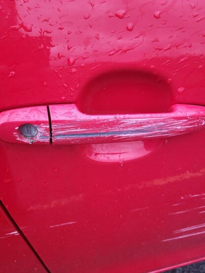 The door handle that took most of the damage, deep scratches down to the metal on a red car.
