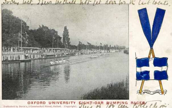 Old postcard showing a rowing race at Oxford during eights week. The landscape orientation card has a monochrome photograph of a rowing race on the river, four boats racing in a line; on the river bank are several barges with crowds on them, and beyond them trees. To the right of the card is a sketch of the Christchurch College Oxford colours, blue with a white cross, and blue oars. Printed on the foot of the card in red capitals is "Oxford University eight-oar bumping races", and there is a handwritten message top and bottom, mostly illegible