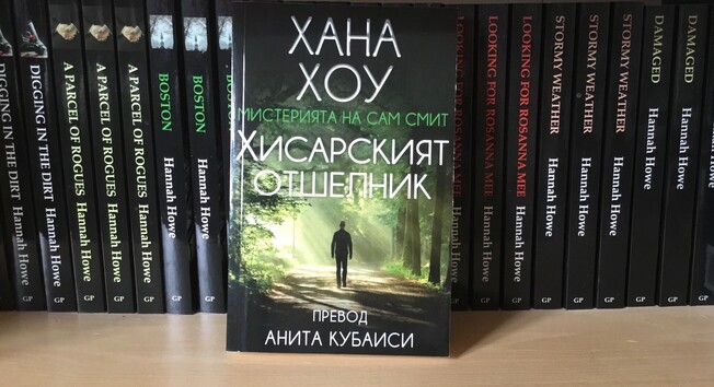 Books on a bookshelf,, including a man walking in a forest