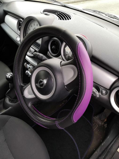 Interior of a Mini One, with a purple-accented steering wheel cover.