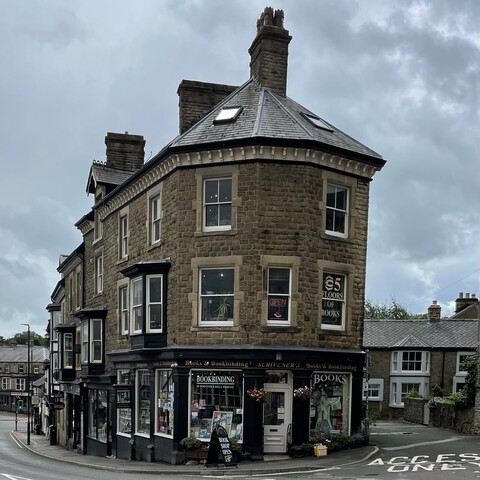 Exterior photo of Scrivener’s Bookshop on Buxton High Street, a Victorian brick corner building with four floors above ground and a cellar full of second-hand books.