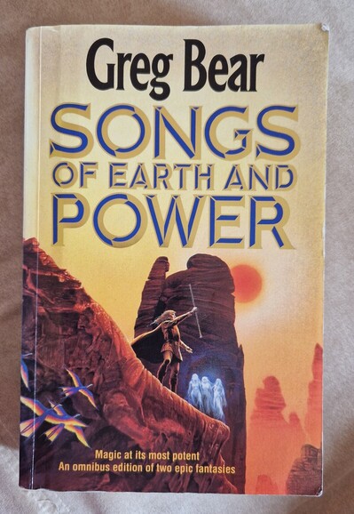 Front cover of the book "Songs of earth and power" by Greg Bear. The central character, Michael Perrin, stands on the edge of a red cliff with a towering rock formation behind. He holds a staff at arms length to the sky. Further along the edge of the cliff are three shimmering white figures of the Sidhe. Four strange looking birds are flying up the cliff face towards him. The burning orange sun hangs heavy in the misty yellow sky.