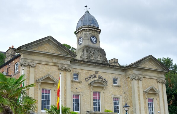 A photo of the upper front of the old Penarth custom house, now a restaurant. It has a central clock tower 