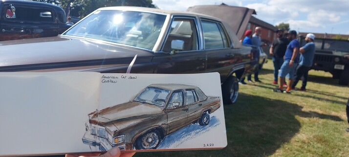 Huge, brown, American car. Very boxy with plenty of sharp edges and angles. The back is up.