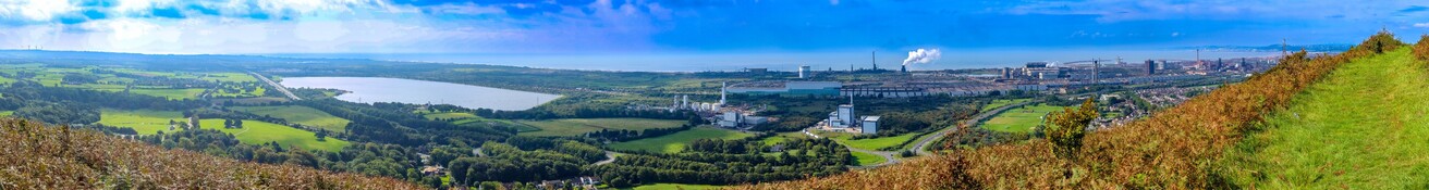 A Panoramic shot from the hills above Margam:

Looking from a grassy path above a steep bracken covered slope that leads down to the M4 motorway, which can be seen disappearing into the distance in the left of the photo. From left to Right, the green fields of Margam Park and a large reservoir either side of the motorway give way to the industrial structures of the Tata Steel plant, which stretches to rightmost of the photo. In the distance Swansea and the Gower coastline can be made out over Swansea Bay