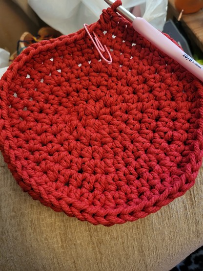 Start of another basket, red base, and will have white walls. Pink crochet hook at the back next to the link paperclip stitch marker. 
