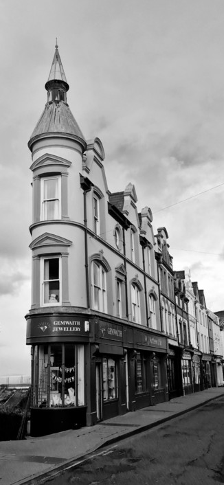 The gemwaith (jewellers) in Caernarfon. An usually narrow corner building with a round, pointed tower.