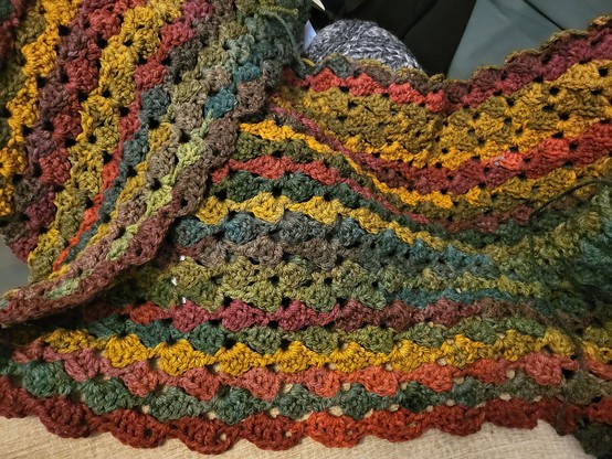 Crocheted blanket, drunken granny square, in autumnal colours. 