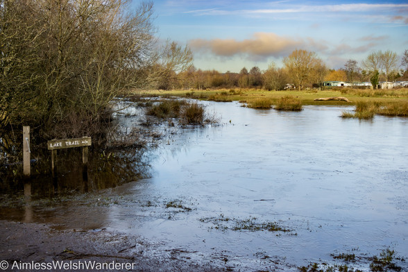 Llangorse Lake Trail, Ice skates needed:
 A small wooden sign, with the words "Lake Trail", an arrow points to the right where a flooded field has frozen over