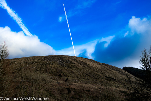 We have lift off:

A plane travels across a deep blue sky above a steep bare hillside, leaving a white contrail stretching behind it. The angle of the photo makes it resemble a rocket blasting straight up from the hill
