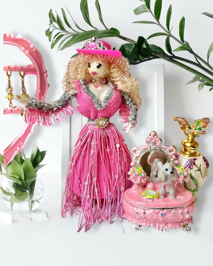 A curvaceous hand made doll in a sparkly pink dress.