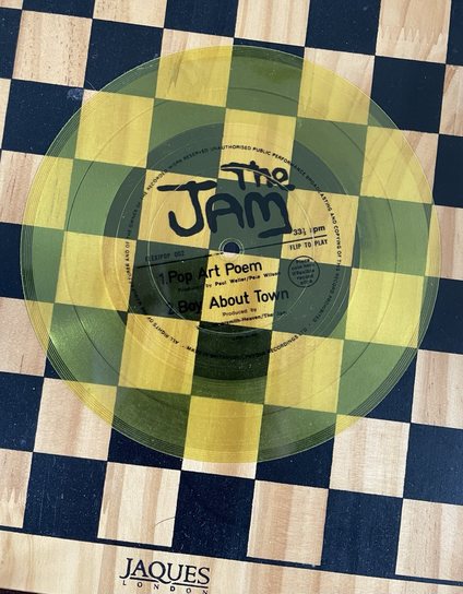 Yellow flexi-disc record by The Jam (on a chess board)