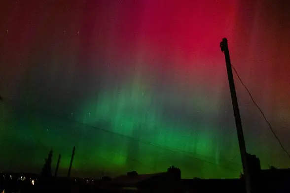 Green and pink aurora lights in the night sky over Ebbw Vale.