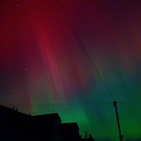 Green and pink aurora lights in the night sky over Ebbw Vale.