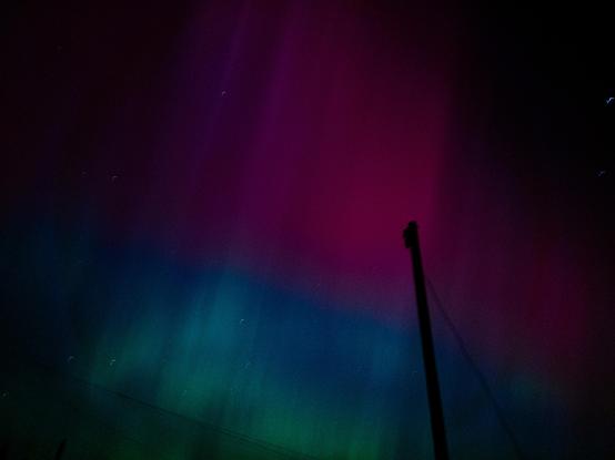Green and pink aurora lights in the night sky over Ebbw Vale.
