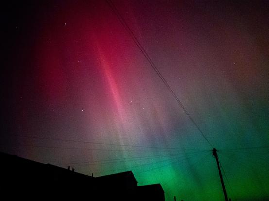Green and pink aurora lights in the night sky over Ebbw Vale.