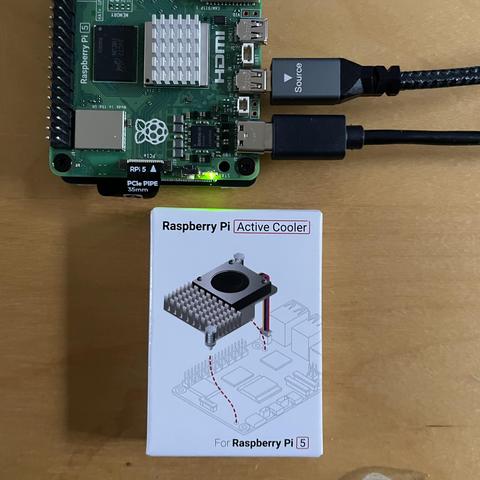 A small white box containing what is described as an ‘Active Cooler’ in the diagram explaining how to attach it to the circuit board above it. 