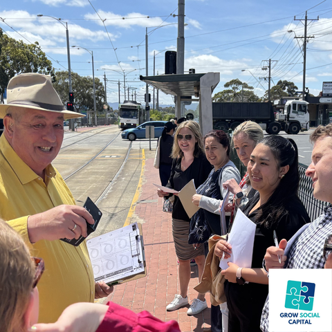 Grow Social Capital founder Andy Green with commuters at a Melbourne tram stop discussing his unique take on nurturing creativity