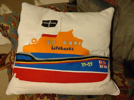 A cushion with lifeboat design made from remnant sailcloth. The boat is 17-29, stationed in Falmouth for 23 years. A rare Severn class since it has no crane for the Y-boat.