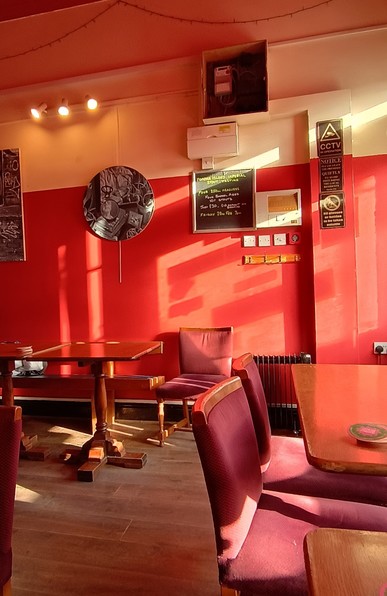 A rather mundane wall in a small bar is suddenly transformed by the arrival of a burst of sunlight.