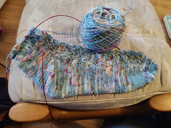 Partially knitted speckled blue sock