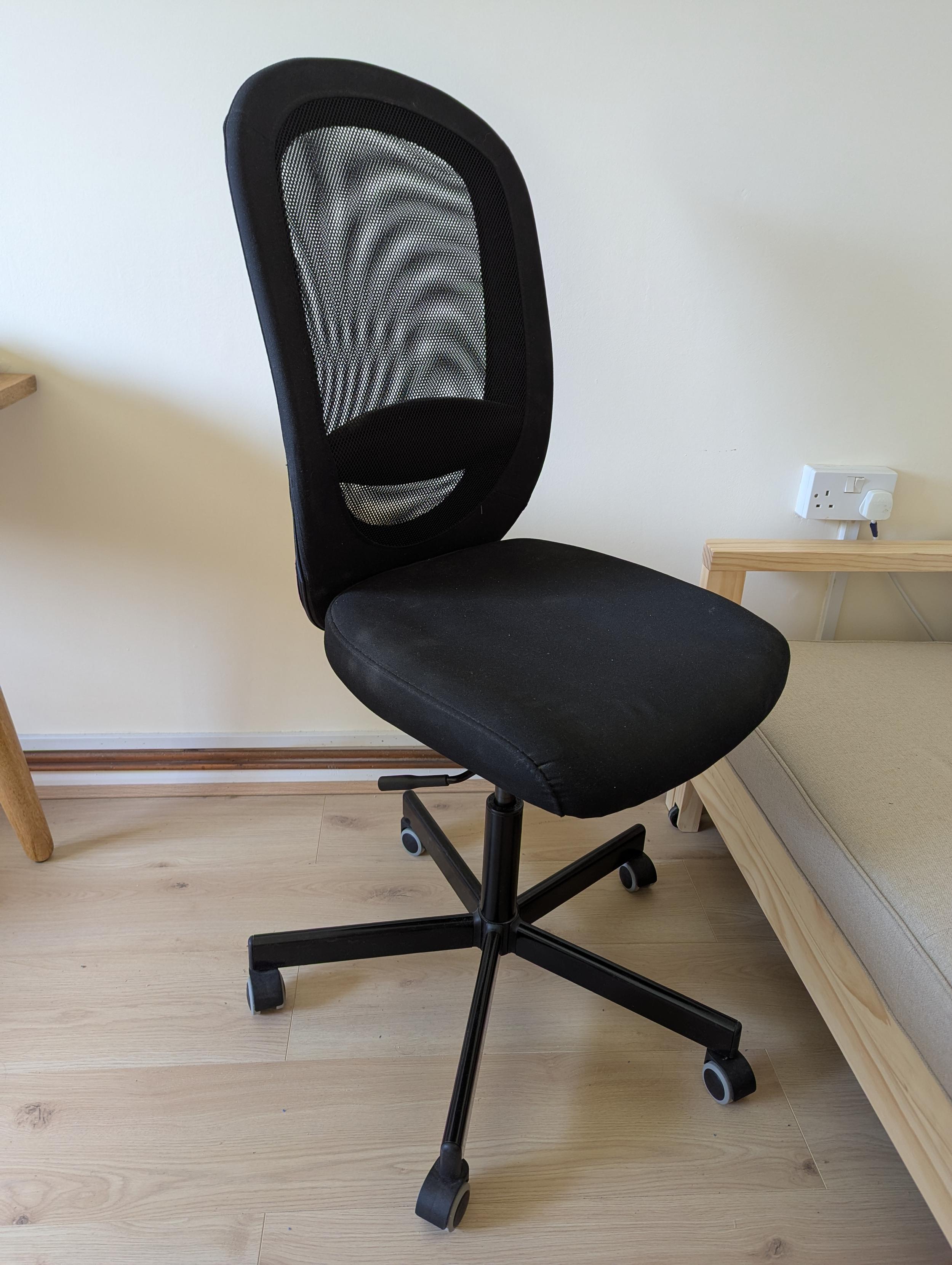 A similar but slightly different desk chair with a black cover and mesh back, and black legs.
