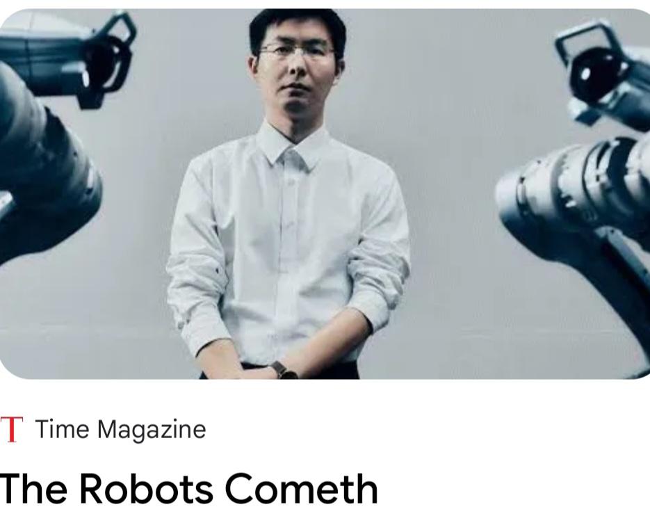 Some bloke with parts of two robot arms in the foreground. 