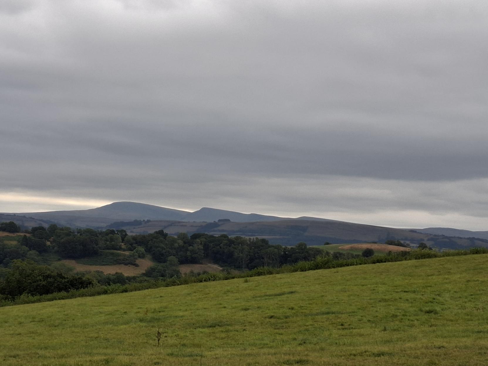 A view across to the Bannau Brecheiniog.  The ground is parched but the air has cooled and the sky is grey. However the forecast is not hopeful and if rain does come it will be from the north west not the south